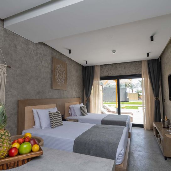 A Bedroom With A Bed And A Table With Fruit On It