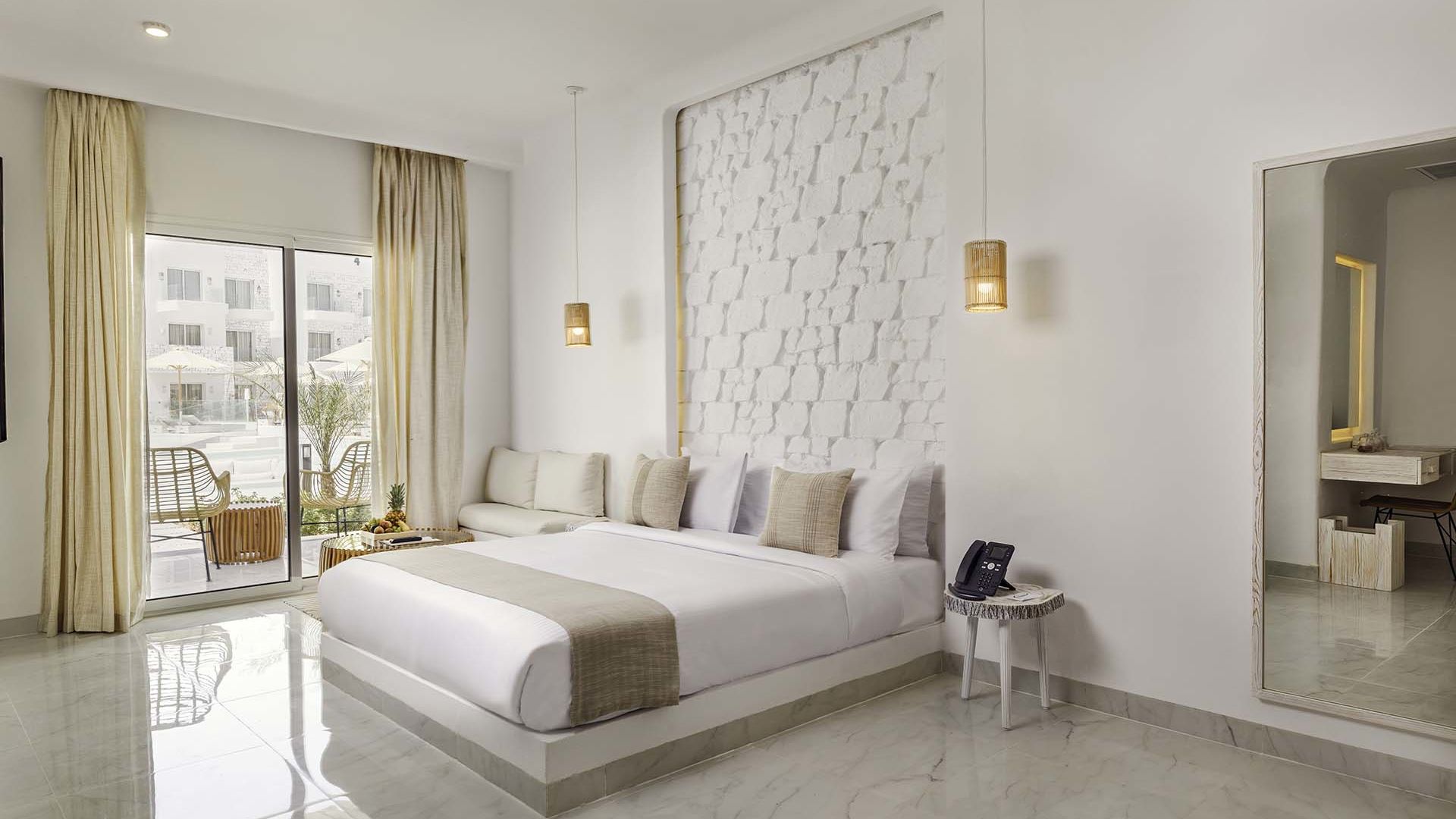 A Large White Room With A Large Glass Door And A Large White Bed